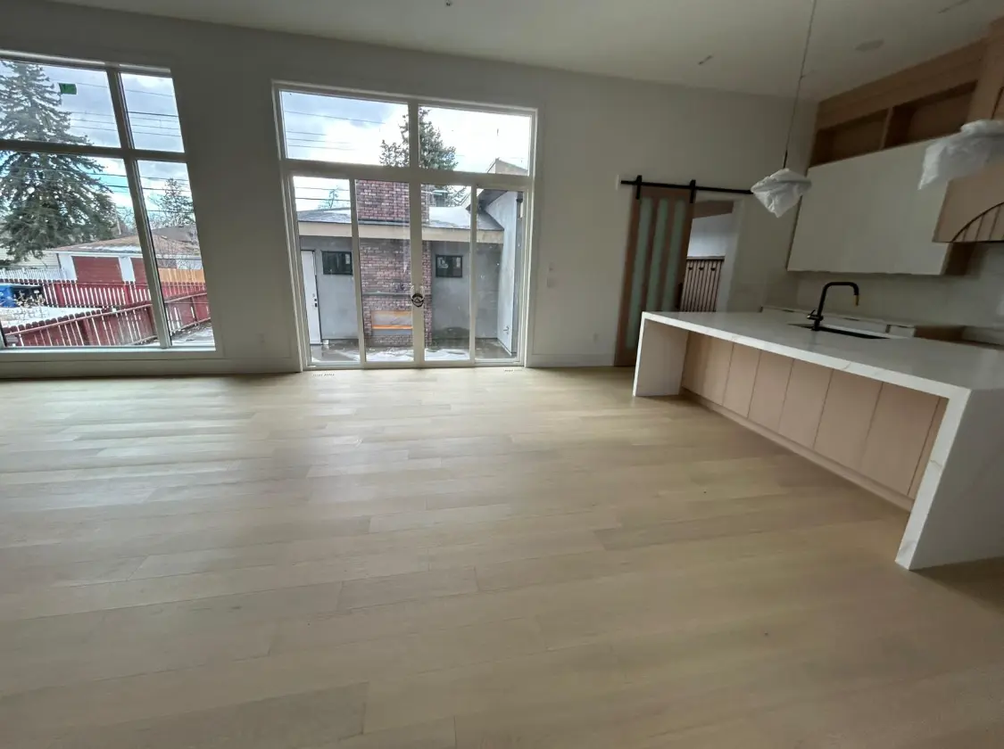 Empty open concept kitchen and living area before luxury home staging